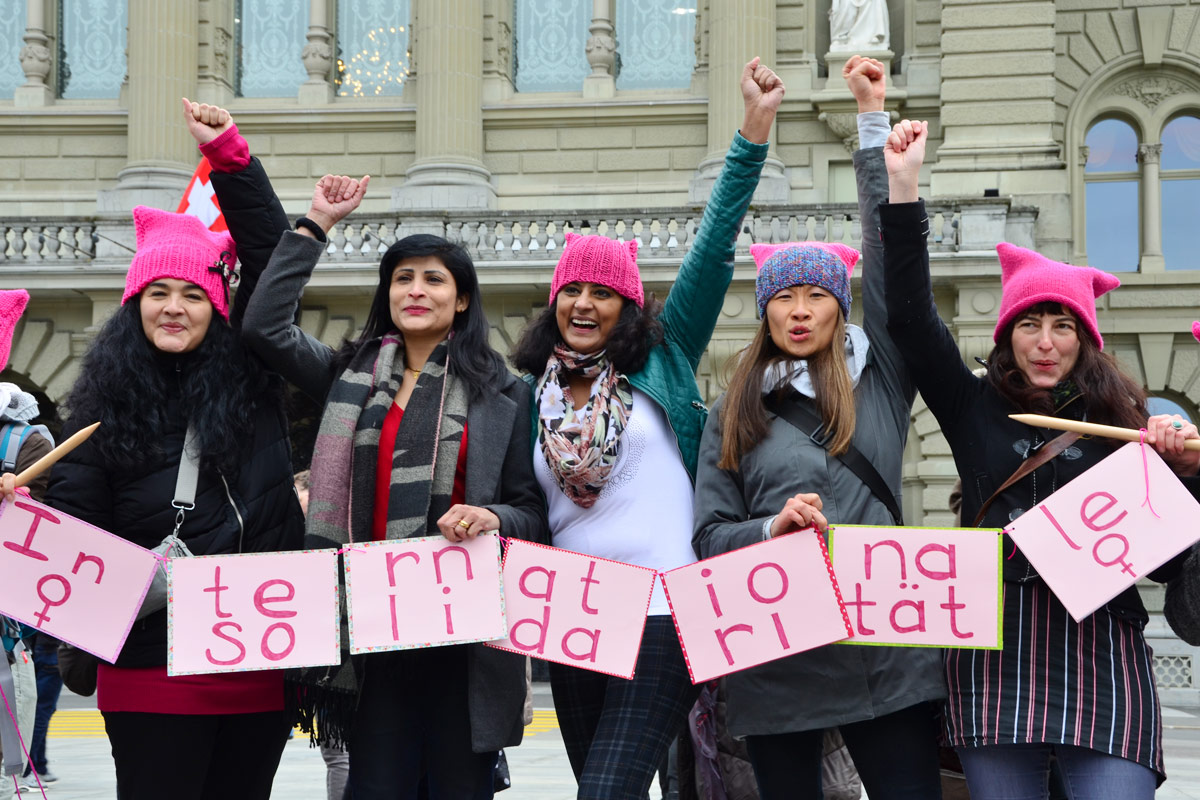 [Translate to Français:] 5 Frauen mit erhobner Faust und Kartons mit der Aufschrift: Internationale Solidarität