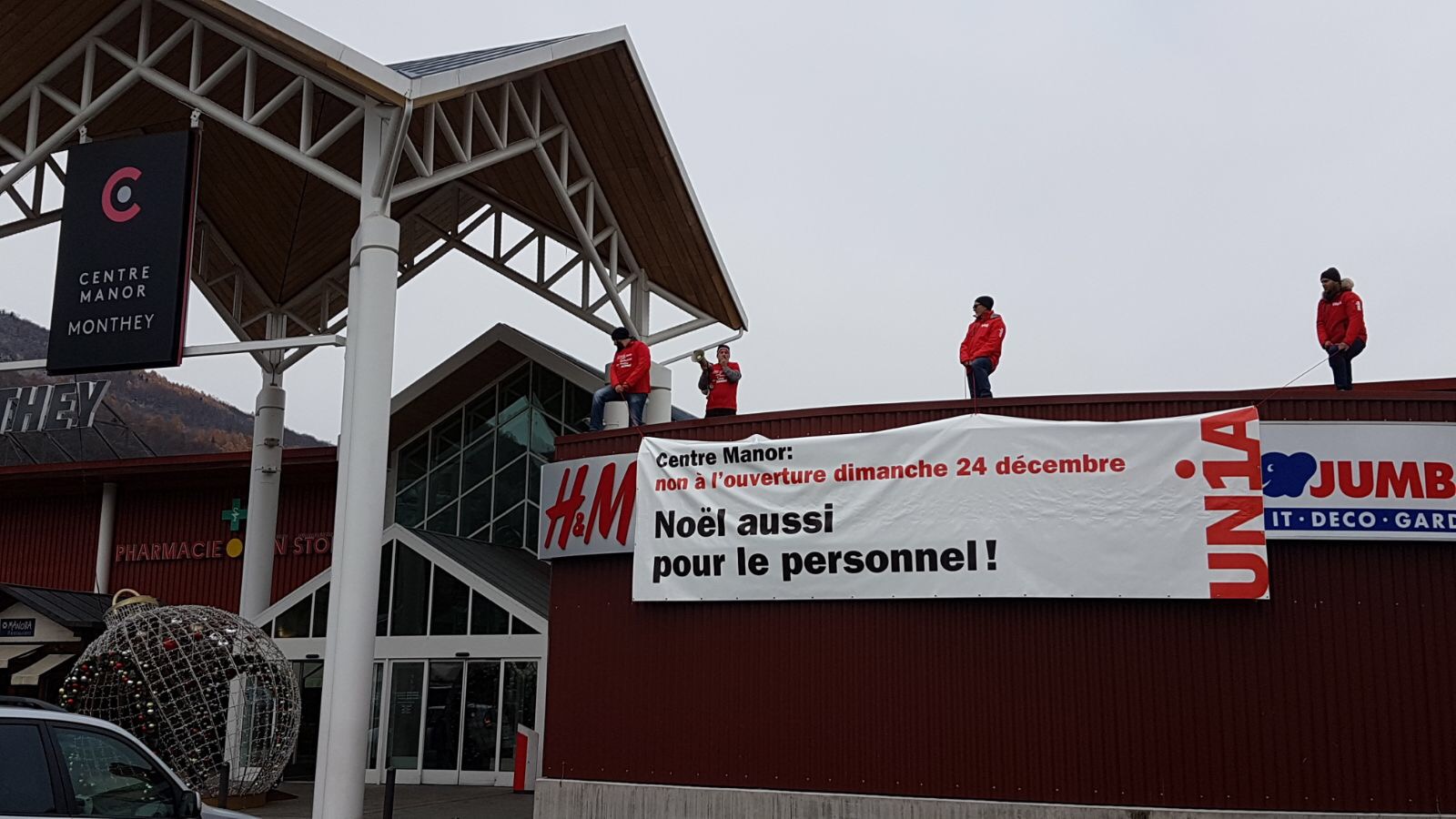 Banderole d'Unia sur la fassade de Manor à Monthey