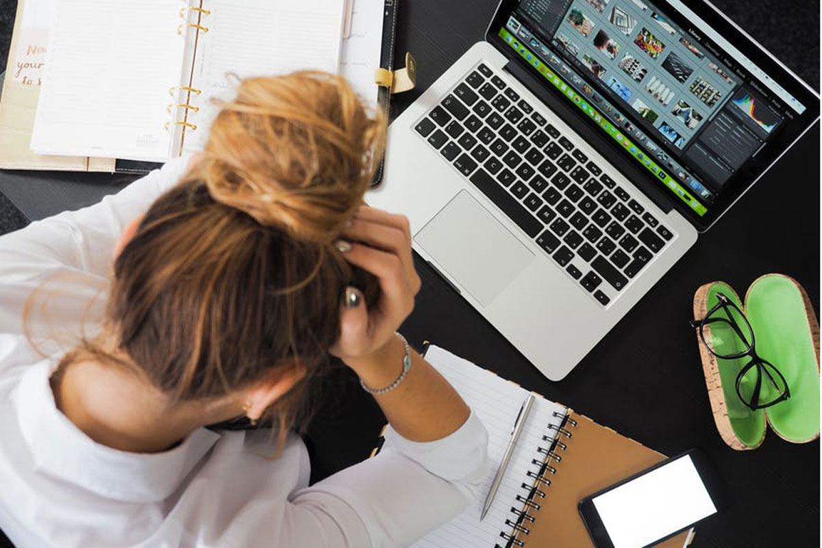 Erschöpfte junge Frau vor einem Computer