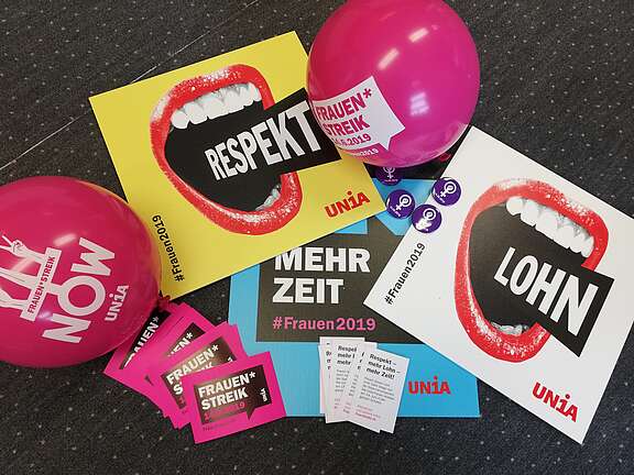 Schilder, Flyer, Buttons, Kleber und Ballone des Frauenstreiks