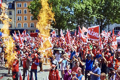 Pyrotechnische Effekte steigen im Vordergrund einer Unia-Demonstration auf