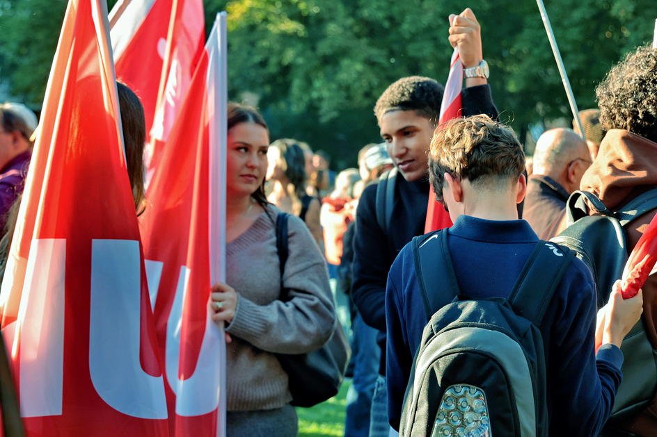  Des jeunes avec des drapeaux rouges d’Unia au milieu de la foule.