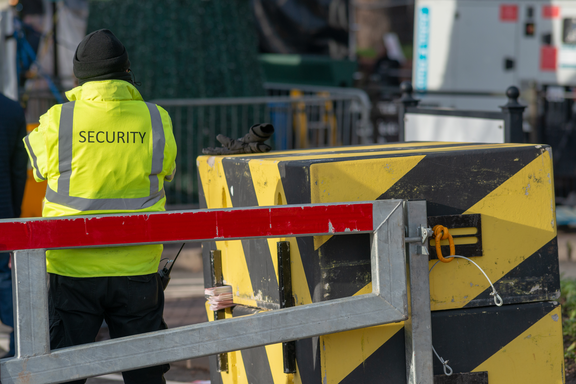 Un agent de sécurité vêtu d'un gilet fluorescent surveille un chantier.