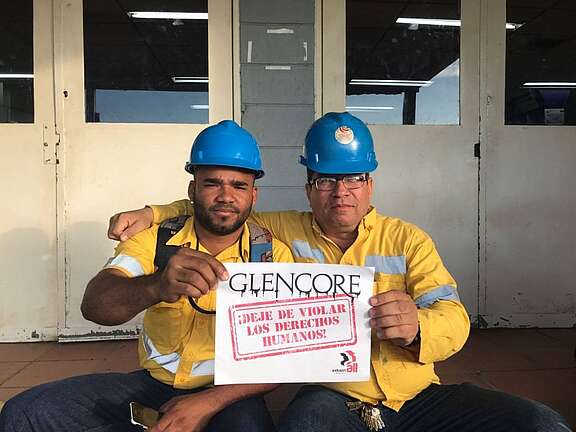 Zwei Arbeiter halten ein Protestschild