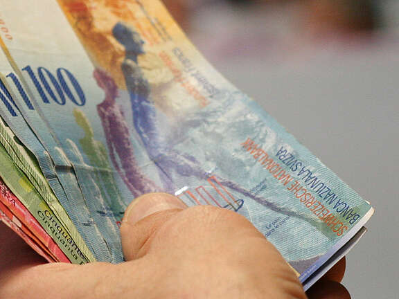 Un éventail de billets de banque dans la main d'une personne