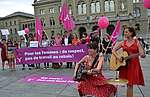 Action sur la Place fédérale avec beacoup de lila et banderole: Nous en avons assez! Égalité salariale maintenant!