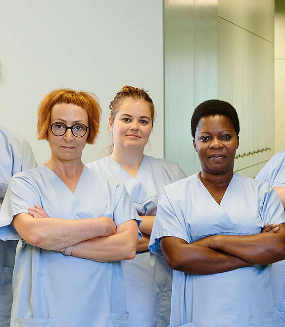 Un gruppo di addetti e addette alle cure con le braccia incrociate.