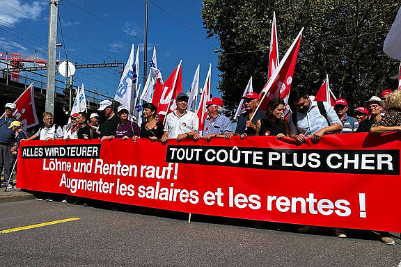 Demo-Teilnehmer:innen mit Transparent: Alles wird teurer. Löhne und Renten rauf! 