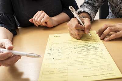 Deux personnes remplissent un formulaire