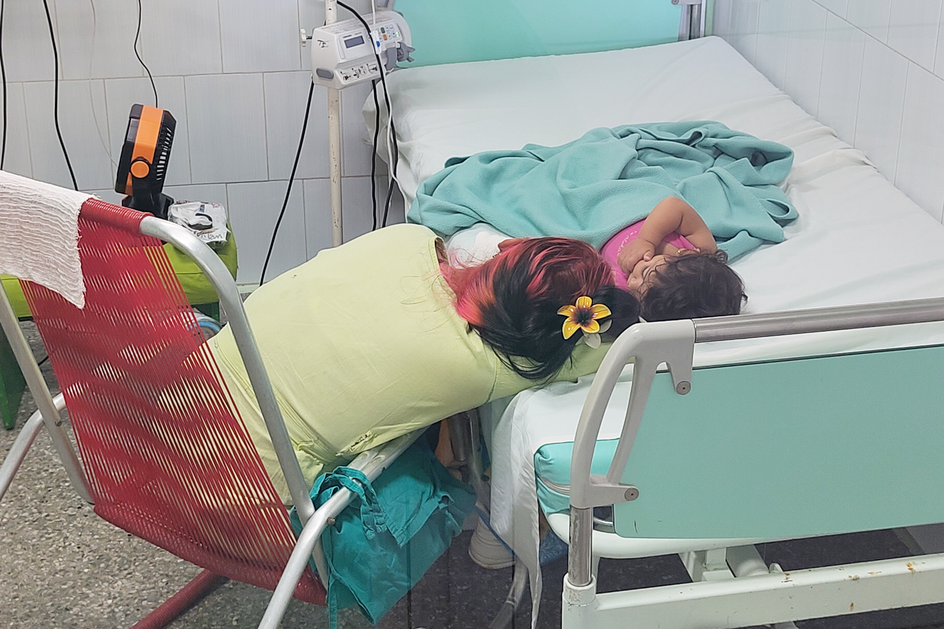 In einem Zimmer des Krankenhauses El Cerro in Havanna sitzt jemand am Bett eines hospitalisierten Kindes.