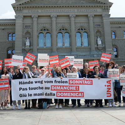 Verkäufer:innen stehen mit Schildern und einem Transparent vor dem Bundeshaus und fordern: «Hände weg vom freien Sonntag!»