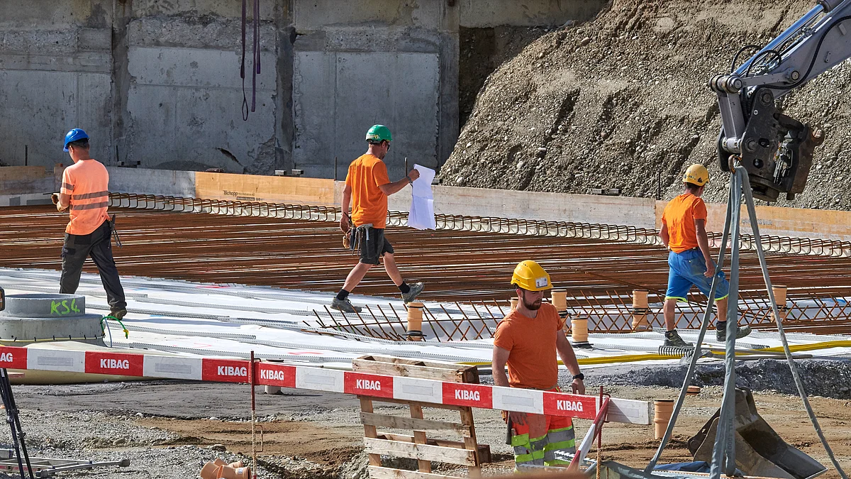 Bauarbeiter mit Schutzhelmen auf einer grossen Baustelle