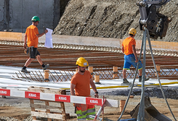 Bauarbeiter mit Schutzhelmen auf einer grossen Baustelle