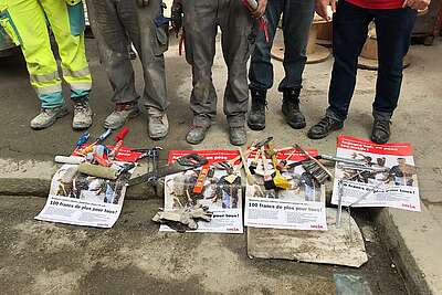 Outils, flyers d'Unia et chaussures de chantier