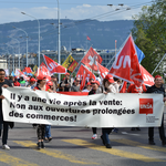 Les membres d’Unia manifestent avec des drapeaux et une banderole contre l’extension des horaires d’ouverture des commerces: 