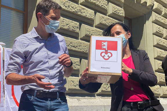 Vania Alleva, Präsidentin der Unia und Nico Lutz, Unia-Geschäftsleitungsmitglied reichen eine Schachtel mit Unterschriften weiter