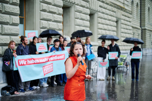 Un groupe de jeunes professionnels s'est réuni. Ils remettent des paquets avec des signatures à une représentante de la Chancellerie fédérale à l'attention du Conseil fédéral.
