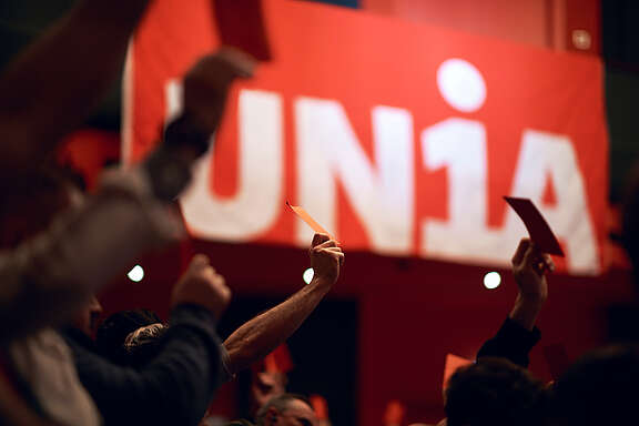 Des travailleurs de la construction réunis en assemblée.