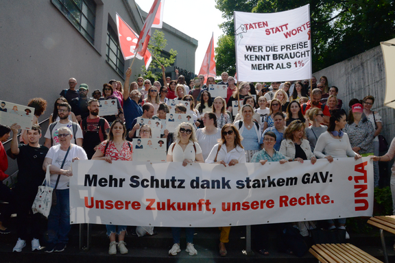 Coop-Angestellte stehen hinter einem Transparent mit der Aufschrift «Mehr Schutz dans starkem GAV: Unsere Zukunft, unsere Rechte»