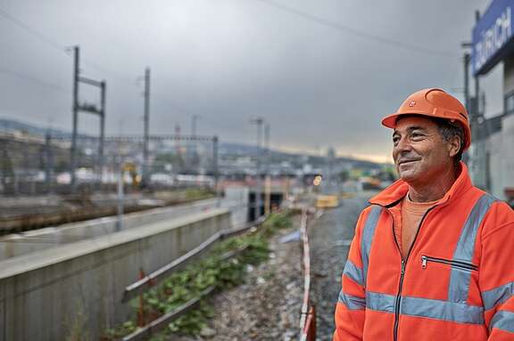 Gleisbauarbeiter schaut über die Gleise in die Ferne