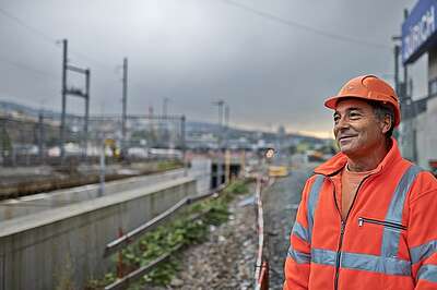Gleisbauarbeiter schaut über die Gleise in die Ferne