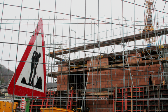 Achtung Baustelle! Symbolbild. Schild hinter Gittern.