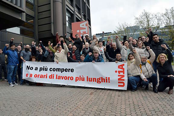 I/Le partecipanti alla Conferenza professionale mostrano uno striscione per dire no all’estensione degli orari di apertura dei negozi e a orari di lavoro più lunghi.