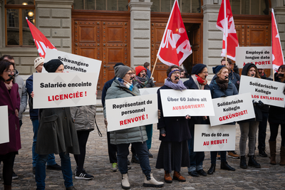 Groupe de syndicalistes portant des pancartes contre les licenciements abusifs