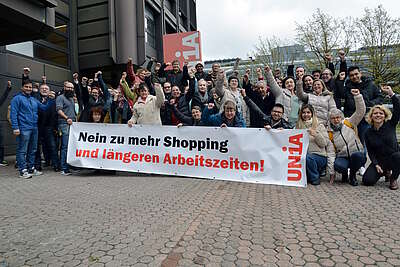 Teilnehmende der Branchenkonferenz Detailhandel halten ein Transparent, auf dem «Nein zu mehr Shopping und längeren Arbeitszeiten!» steht.