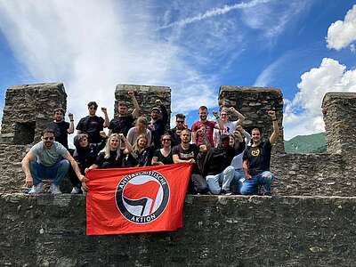 Giovani associati e associate del sindacato Unia issano il loro striscione sul Castel Grande di Bellinzona, manifestando a favore della tolleranza e della solidarietà e contro l’odio e la violenza 