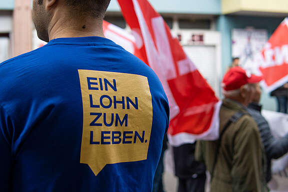 Mann in T-Shirt mit Aufschrift: Ein Lohn zum Leben.