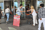 Protesta di prima mattina davanti all'ingresso della Migros contro i tagli ai posti di lavoro. Distribuiscono volantini e spille.