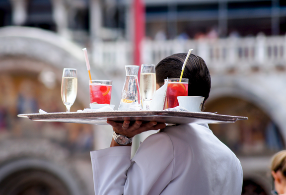 Un serveur de dos avec un plateau de boissons.