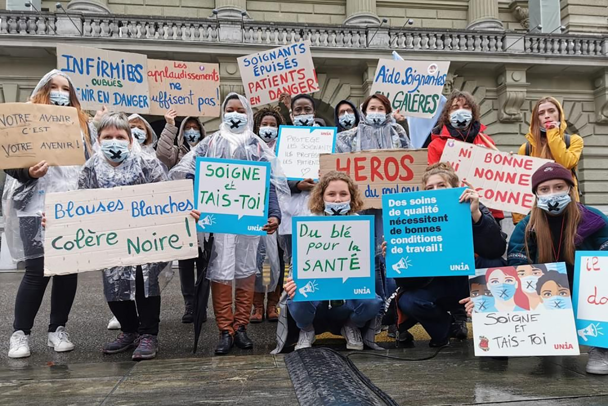 Des soignant-e-s à une manifestation avec des pancartes 
