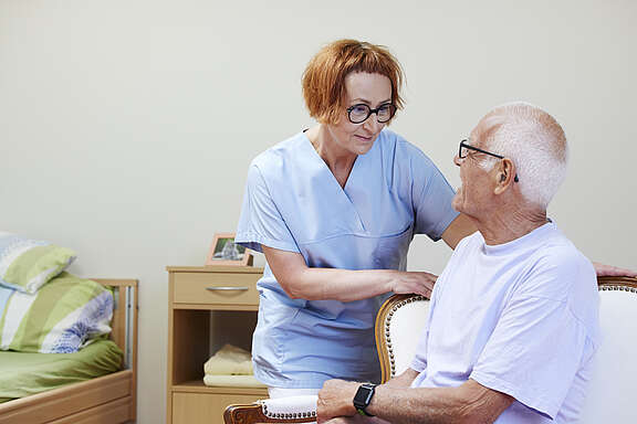 Una curante si occupa di un uomo anziano