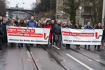 Manifestazione con striscione sul quale si legge: la linea rossa della protezione dei salari