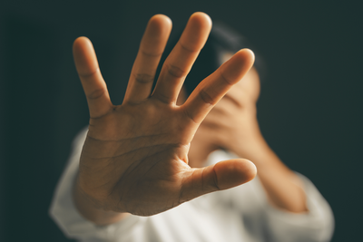 Un homme tend sa paume ouverte en signe de défense.