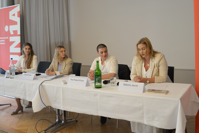 Quattro persone sono sedute a un tavolo e presentano ai media il risultato del sondaggio condotto tra le apprendiste e gli apprendisti.