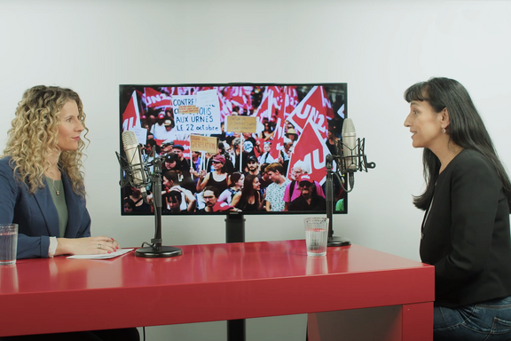 Aufnahme mit Vania Alleva an einem roten Tisch mit drei Mikrofonen