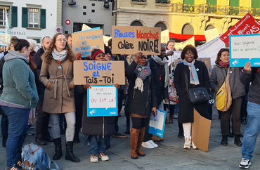 Des soignant-e-s avec des pancartes lors d’une action pour les soins