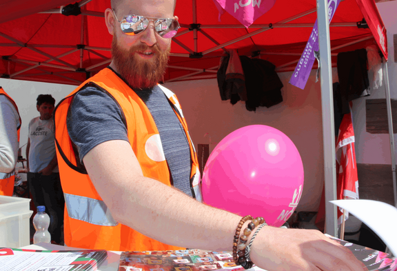 Un employé d'Unia à un stand lors d'une action