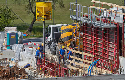 Quatre travailleurs de la construction en train d’effectuer des travaux de coffrage sur un chantier.