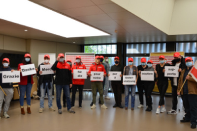 Menschen in einem Raum, die Transparente halten.