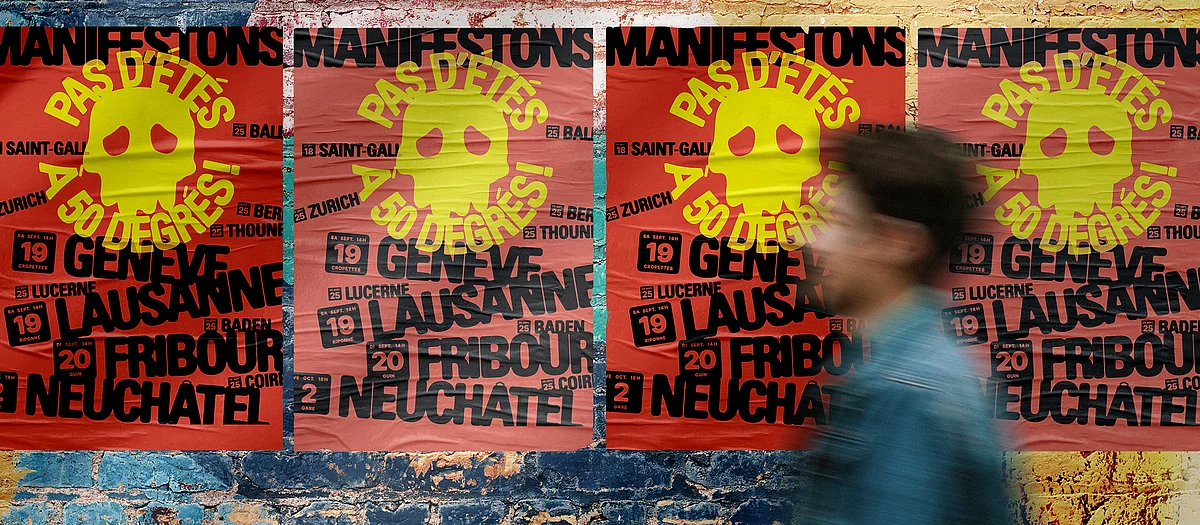 Une personne passe devant des affiches collées sur un mur, sur lesquelles on peut lire: «Pas d'étés à 50 degrés. Manifestations. Lausanne, Genève. 19 septembre.»