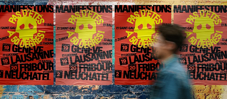 Une personne passe devant des affiches collées sur un mur, sur lesquelles on peut lire: «Pas d'étés à 50 degrés. Manifestations. Lausanne, Genève. 19 septembre.»