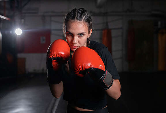 Giovane pugile femminile che indossa guanti da boxe rossi