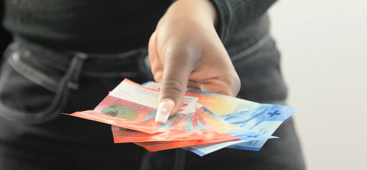 Entgegengestreckte Hand mit Banknoten