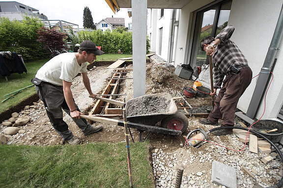 Deux paysagistes travaillant dans le jardin d’une villa.