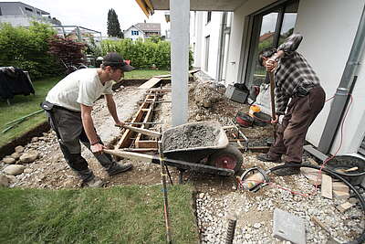 Deux paysagistes travaillant dans le jardin d’une villa.