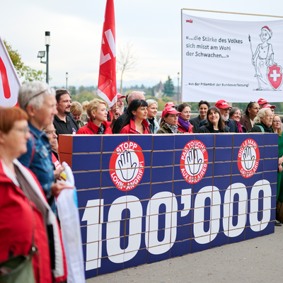 Die Unia und weitere Organisationen reichen vor der Bundeskanzlei rund 100'000 Unterschriften gegen den Angriff auf die Mindestlöhne ein. Im Zentrum steht eine grosse Mauer aus Karton, auf der die Zahl «100'000» steht.  